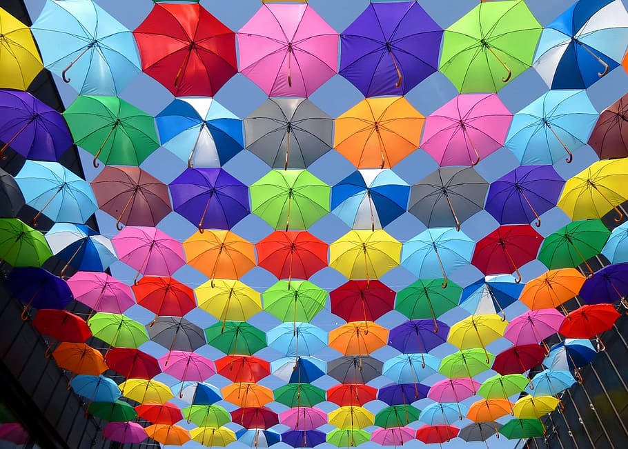 low-angle photography, assorted-color umbrella lot, color, umbrella, red, yellow, blue, purple, blue sky, decorative street