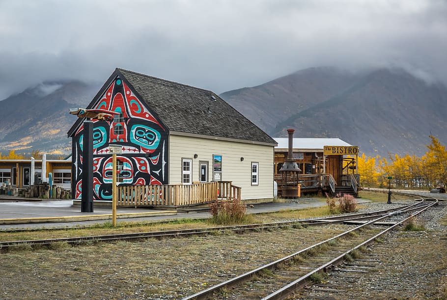 multicolored painted house, carcross, yukon, canada, totem, wall painting, train track, mountain, alaska highway, rail transportation