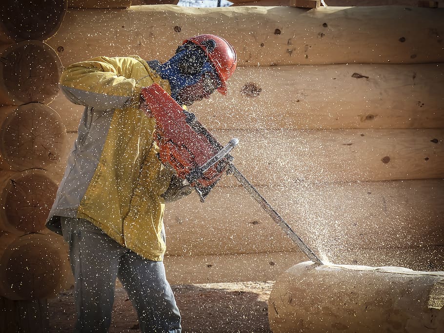 man holding chainsaw, log building, house style, wooden, worker, chainsaw, carving, wood, logs, human