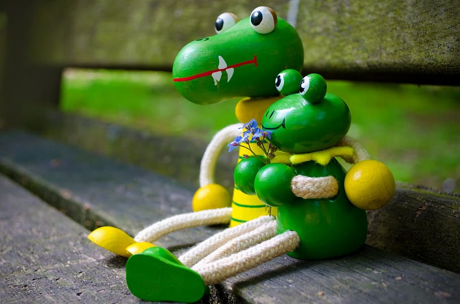 two, green, frog, crocodile toys, sitting, brown, bech, couple, girlfriend, boyfriend