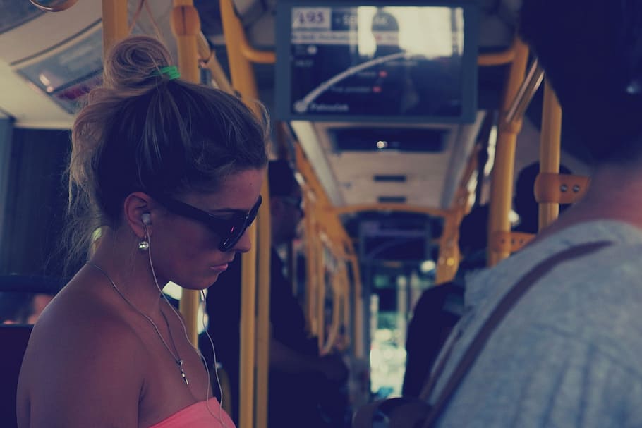 mulher, em pé, interior, trem, menina, ônibus, transporte, pessoas, óculos de sol, fones de ouvido