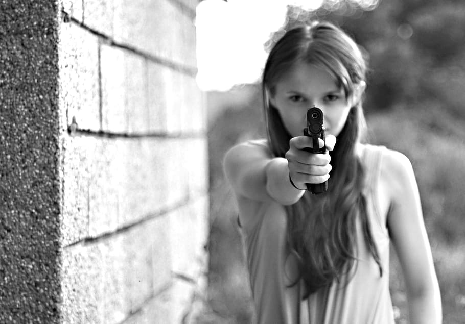 woman, wearing, sleeveless, top, pointing, gun, concrete, wall, black, young woman