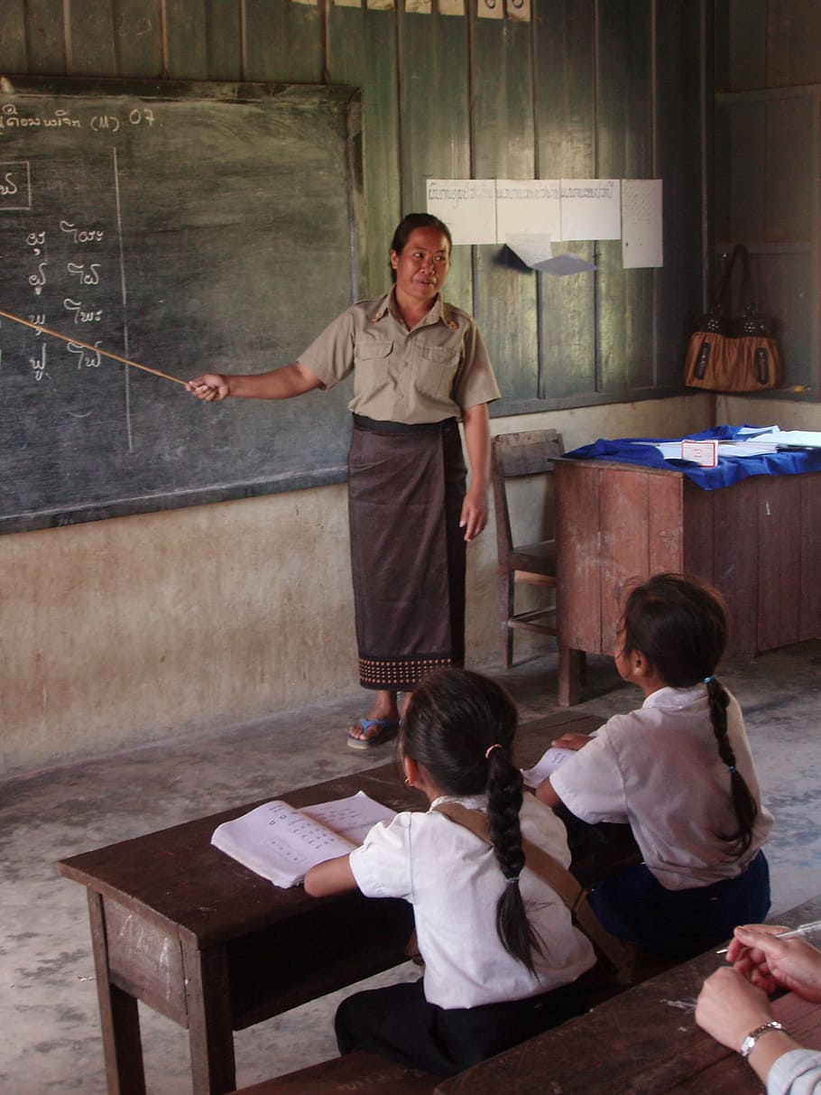 Mujer, de pie, dentro, habitación, al lado, pizarra, estudiantes, escuela primaria, pueblo, Laos