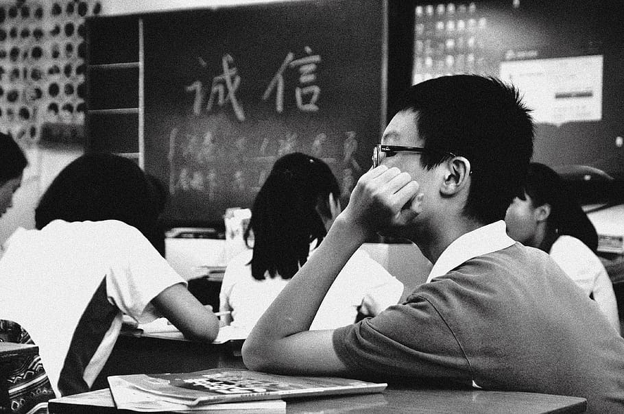 grayscale photo, boy, inside, classroom, students, school, sad, education, young, people
