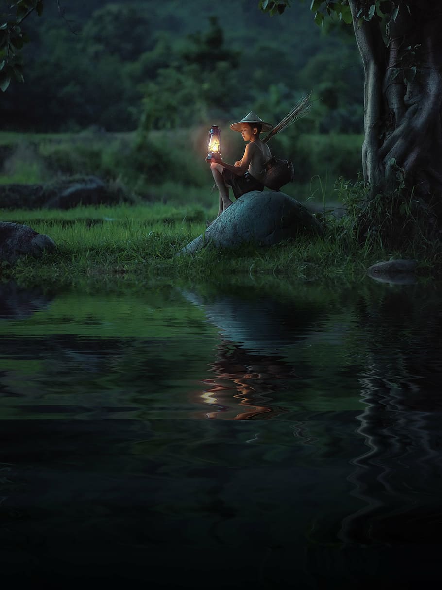 boy, holding, kerosene lamp, sitting, stone, river, background, pretty, blue, bright