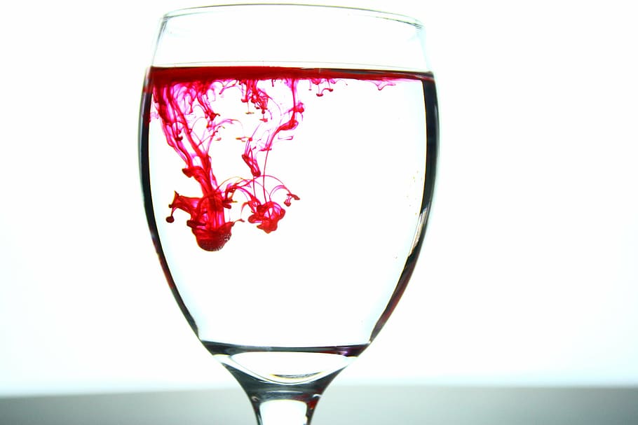 closeup, clear, glass footed wine cup, filled, pink, liquid, glass, ink, droplet, light