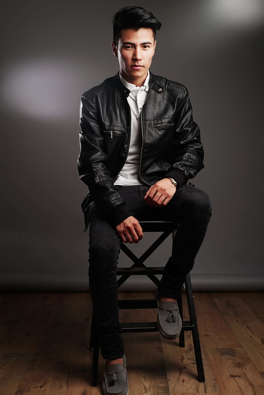 man, wearing, black, leather zip-up jacket, pants, sitting, stool, model, photoshoot, people