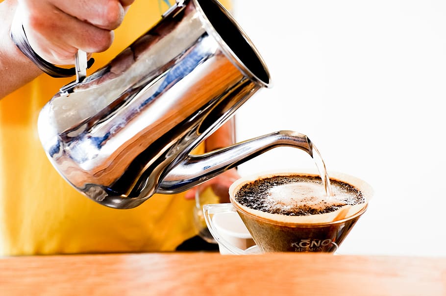person, pouring, water, glass coffee cup, coffee, pitcher, pour, hand, wooden, table