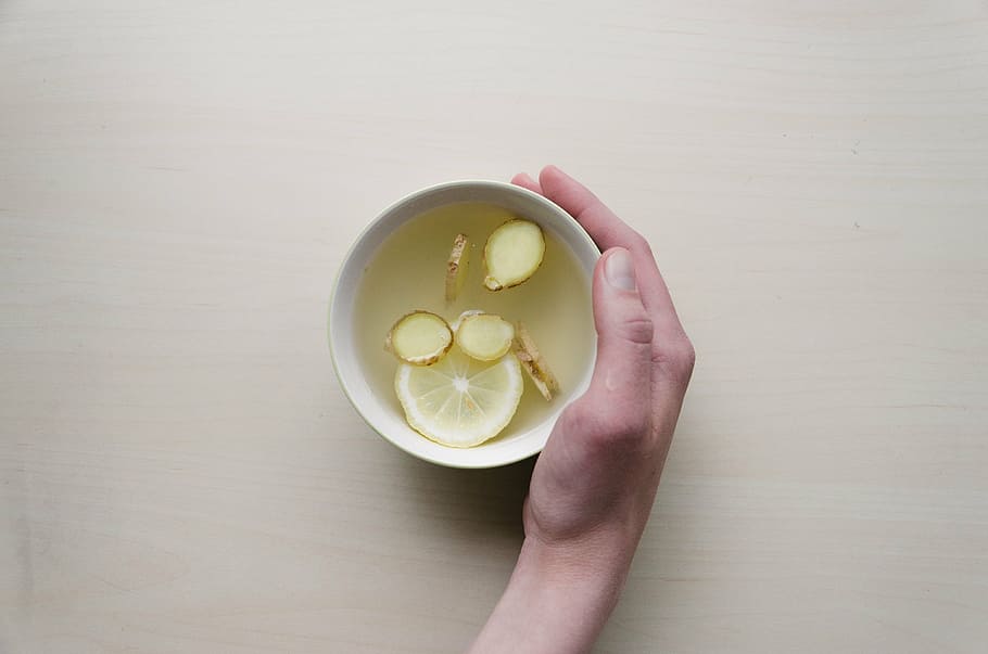person, holding, white, ceramic, cup, sliced, ginger, lemon, bowl, tea