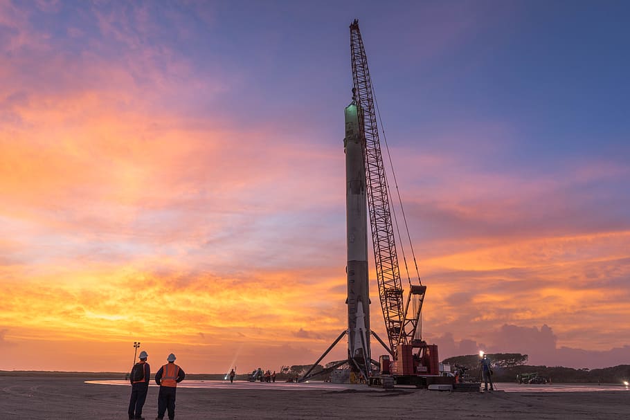 Falcon 9, LZ 1, two, men, standing, crane, tower, golden, hour, sunset