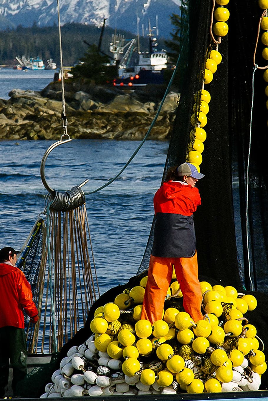 person, standing, ship, holding, yellow, rope, man, wearing, black, red