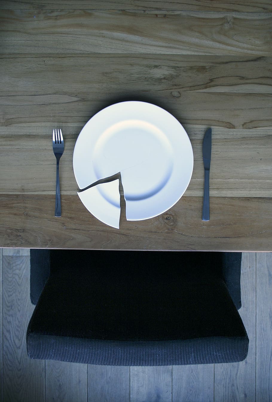 broken, round, white, ceramic, plate, gray, stainless, steel fork, butter spreader, broken plate on a wooden table