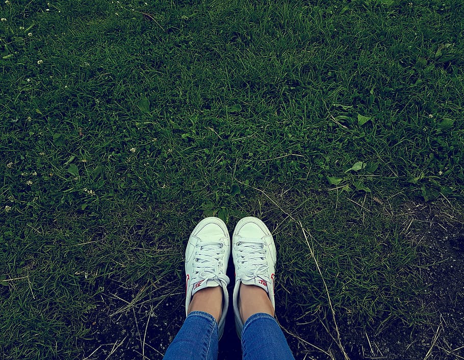 person, wearing, white, low-top sneakers, standing, green, grass, low, top, sneakers