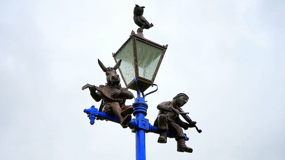 statuettes, playing, instrument, light post sculpture, street, lamp, light, city, illumination, road