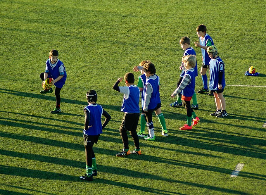 jogadores de futebol, em pé, campo de futebol, durante o dia, rugby, esportes, bola, equipe, crianças, esporte
