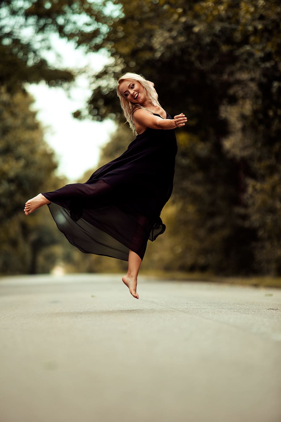 woman, wearing, black, sleeveless dress, bare, foot, jumping, concrete, road, sleeveless