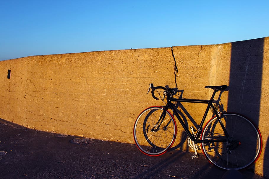 rigid, bike, lean, stone wall, black, road, near, wall, daytime, blue