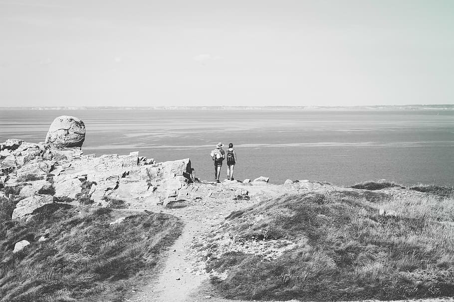 grayscale photo, two, person, standing, towards, sea, grayscale, people, cliff, black and white