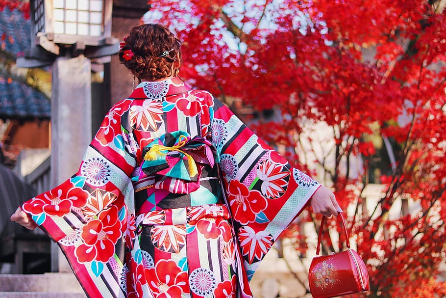 mulher, vestindo, multicolorido, quimono, exploração, vermelho, bolsa de couro, árvore de folhas, dia, couro