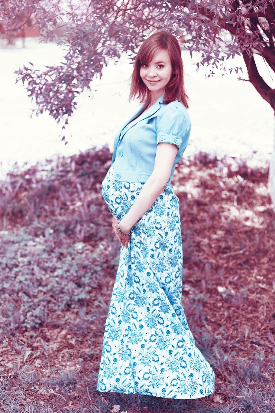 pregnant, woman, wearing, blue, floral, dress, standing, tree, daytime, stand by
