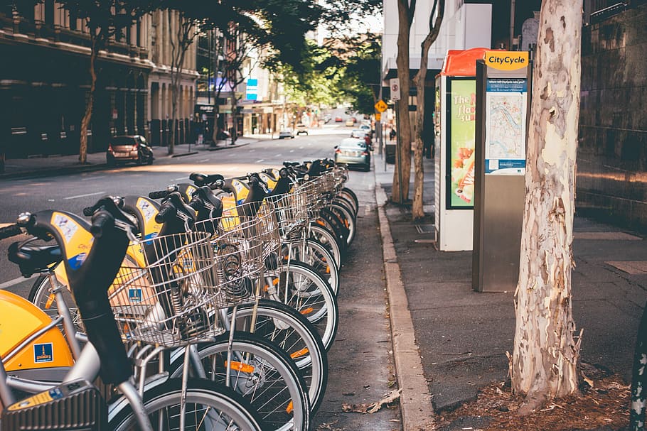 persona, mostrando, estacionado, scooter utilitario, utilidad, scooter, bicicleta, calle, escena urbana, vida de la ciudad