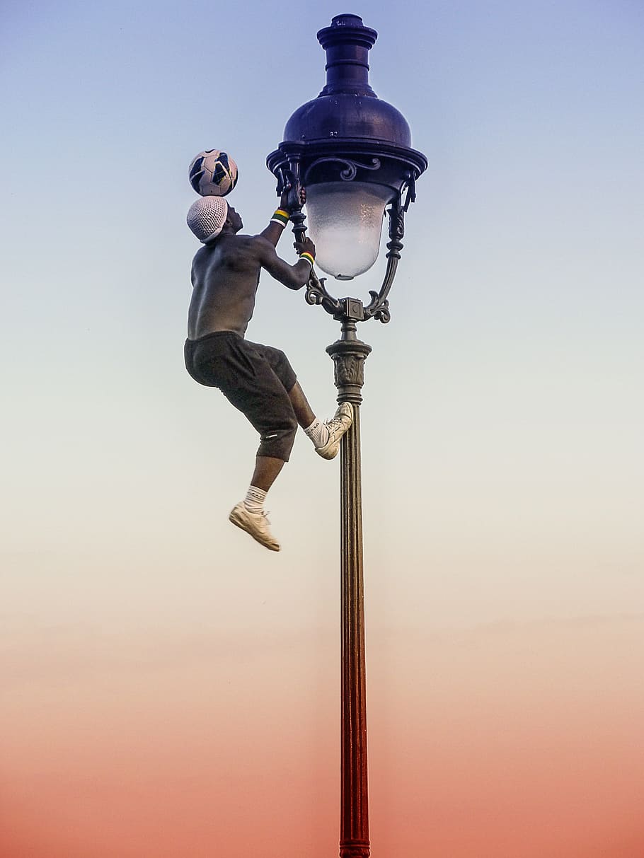 man, wearing, gray, sweat shorts, holding, tower lamp, football, paris, street art, european championship