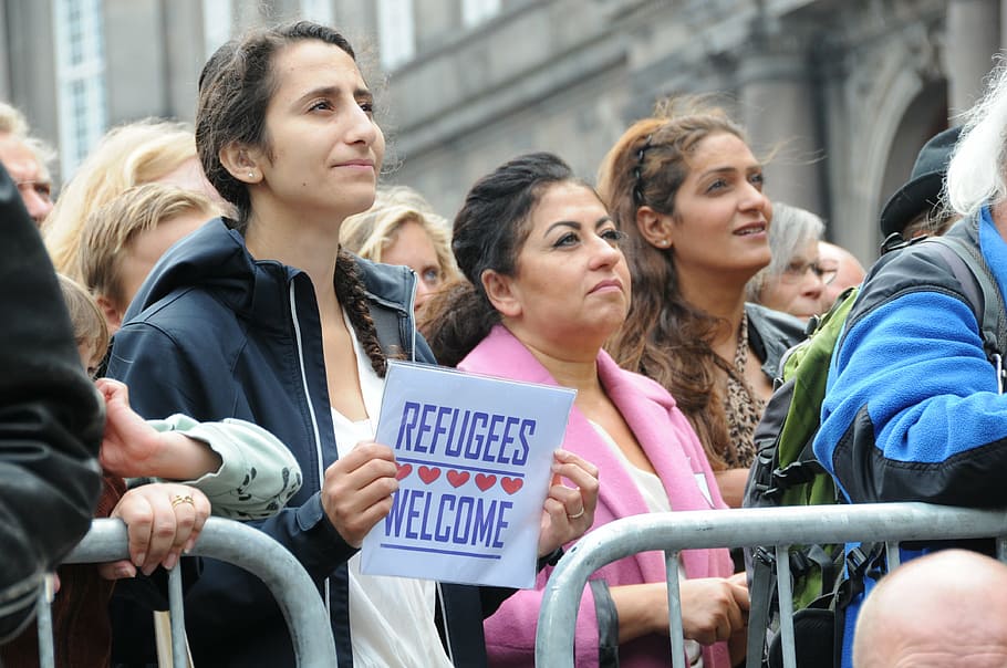 mujer, de pie, sosteniendo, papel, refugiados bienvenidos, manifestación, Copenhague, 2015, frente al parlamento, gente