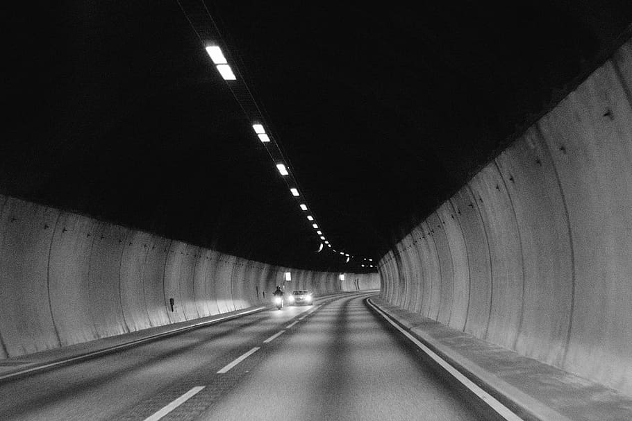 grayscale photo, road tunnel, motorcycle, car, tunnel, road, pavement, cars, motorbike, lights