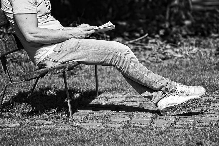 grayscale photography, person, sitting, bench, man, reading, outdoors, body, leg, foot