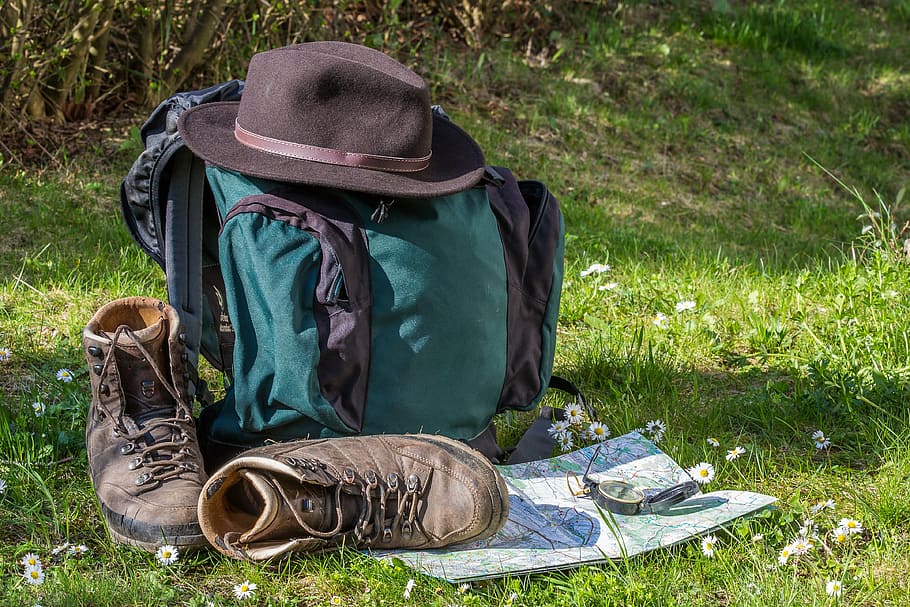 black, green, backpack, fedora hat, grassland, hiking, map, orientation, hiking shoes, hat