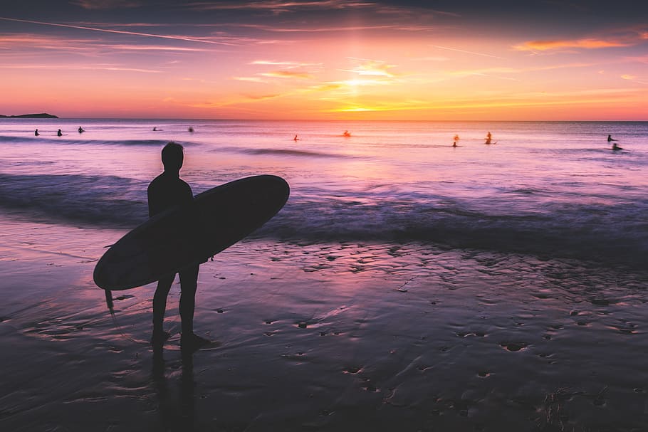 surfista, stands, playa, miradas, océano, puesta de sol., capturado, en la playa, puesta de sol, imagen