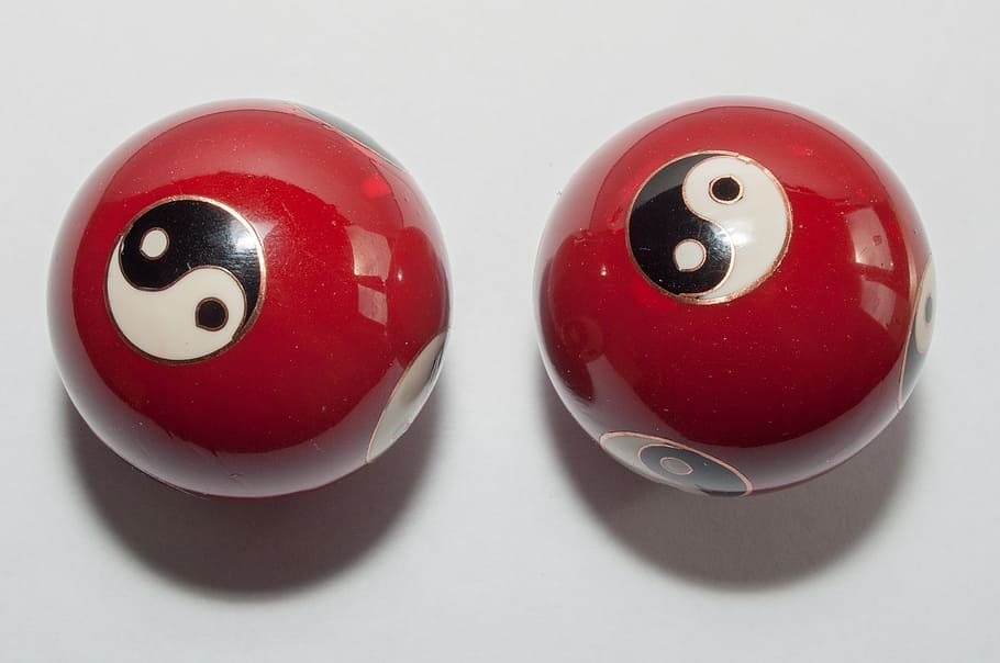 qi gong, balls, red, hollow balls, yin, yang, metal, close-up, two objects, indoors