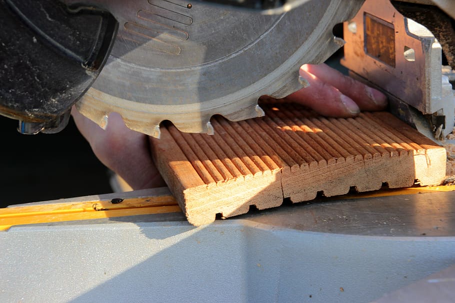 man, using, miter, saw, crosscut saw, saw blade, teeth of the saw blade, not saw in operation, wooden board, bangkirai