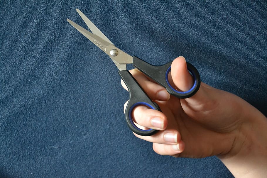person holding scissors, a pair of scissors, scissors, thread, cut, cut off, indent, human body part, human hand, hand