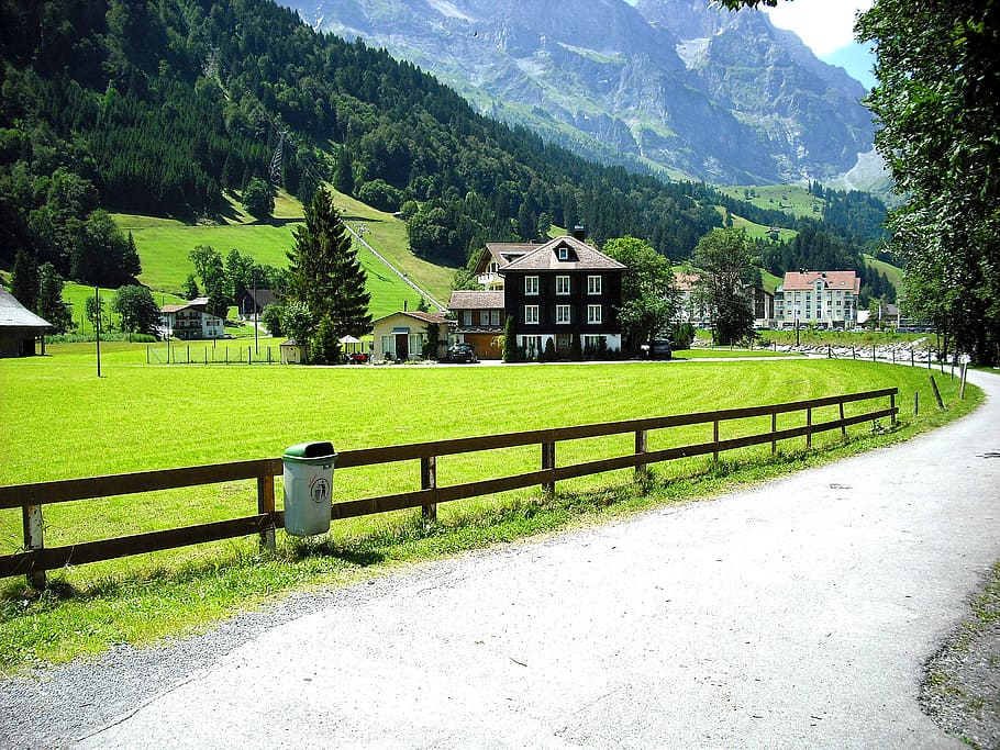 marrón, negro, concreto, casa, montaña, durante el día, camino a través del pueblo, casa en las montañas, suizo, alfalfa