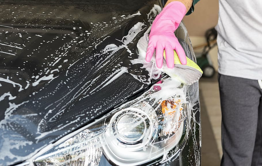 person, wearing, pink, rubber glove, washing, black, car, wash a car, the car, blue