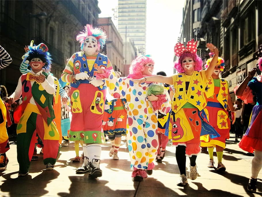group, people dancing, street, daytime, concrete, buildings, clowns, parade, people, costume