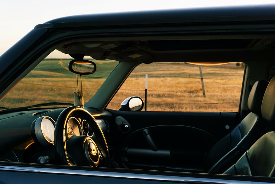 close-up photo, black, leather vehicle, interior, daytime, vehicle, road, near, desert, car