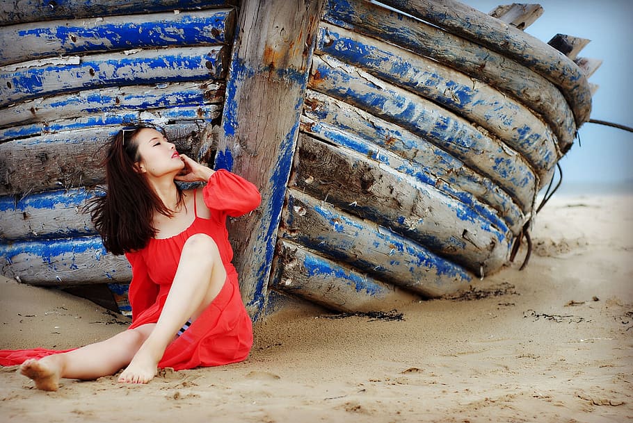 mulher, vestindo, vermelho, vestido de ombro frio, inclinando-se, azul, de madeira, barco, mulher de vermelho, vestido vermelho