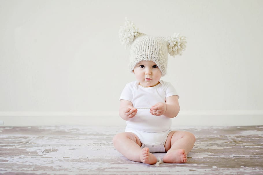 baby, wearing, white, onesie, beige, bubble cap, sitting, floor, on the floor, bunny hat