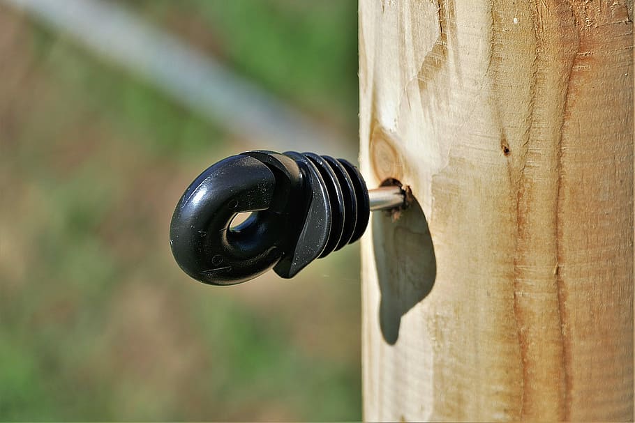 black, tool, brown, lumber, insulator, wooden posts, pasture fence, plastic, focus on foreground, close-up