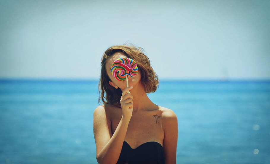 woman, black, strapless, top, holding, lollipop, sea, ocean, candy, outdoor