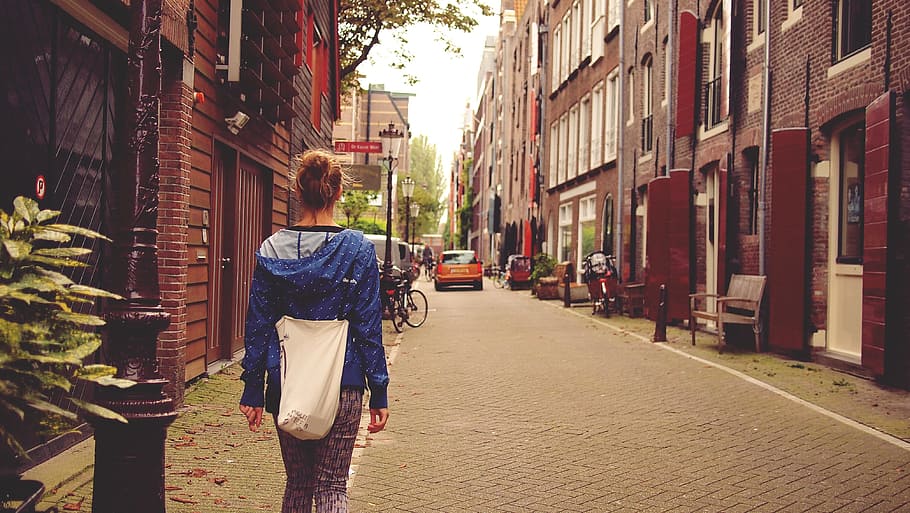 blonde, haired woman, blue, pullover hoodie, standing, brown, pole, amsterdam, travel, netherlands