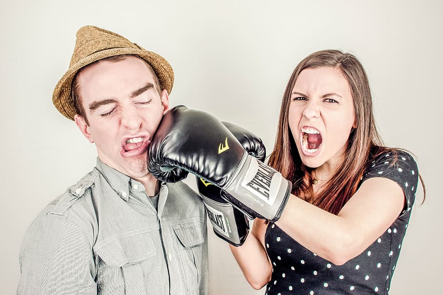 woman, wearing, black, everlast boxing gloves, man, brown, fedora hat, argument, conflict, controversy