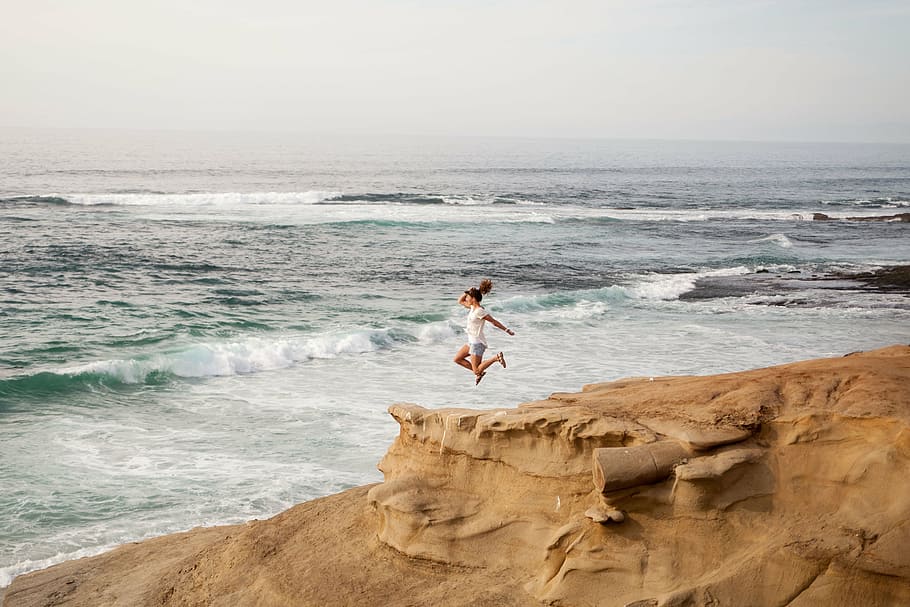 mujer, saltando, colina, océano, durante el día, personas, salto, rocas, olas, mar