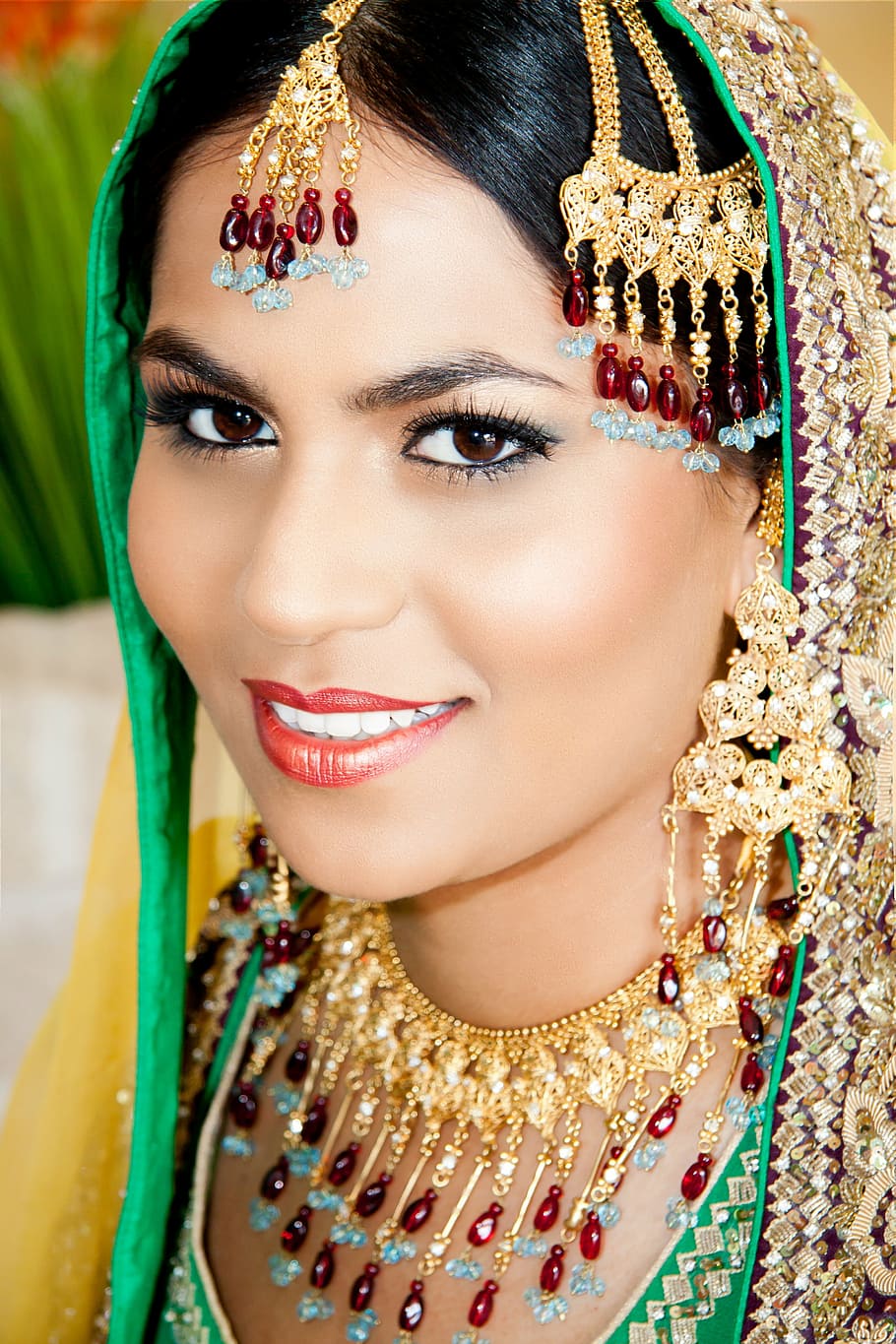 woman, wearing, gold-colored, red, blue, gemstone jewelries, woman smiling, pakistan, indian, culture