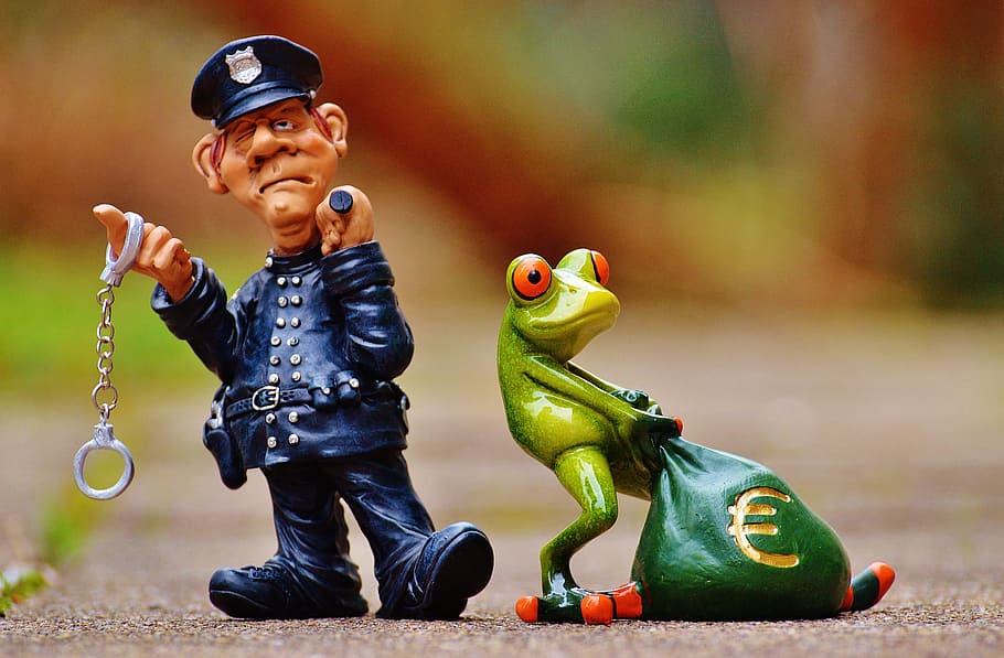 close-up photo, frog, policeman character figurines, taxes, tax evasion, police, handcuffs, scam, tax consultant, finance