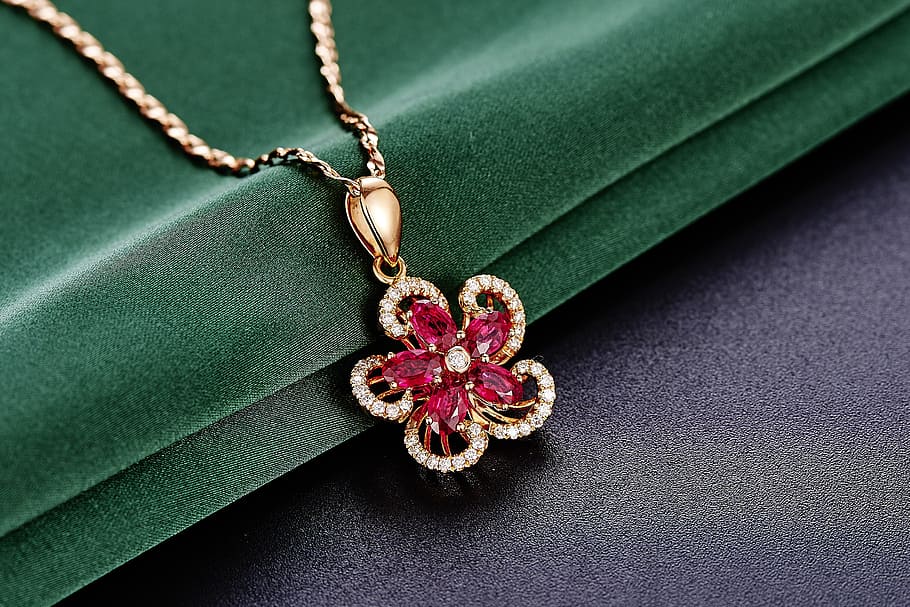 gold-colored, red, gemstone flower pendant necklace, jewelry, ruby, pendant, close-up, green color, indoors, leaf