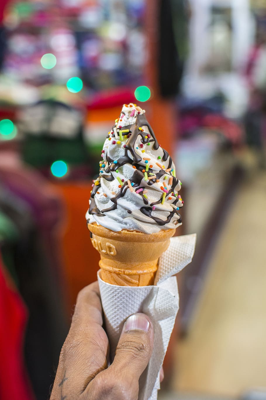 person, holding, wafer cone, soft-served ice cream, topped, sprinkles, chocolate, dessert, ice cream, lights