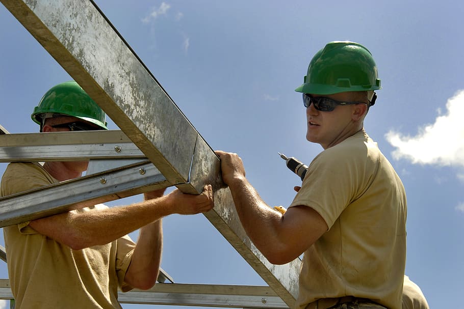 man, wearing, beige, shirt, green, safety helmet, holding, white, steel bars, construction